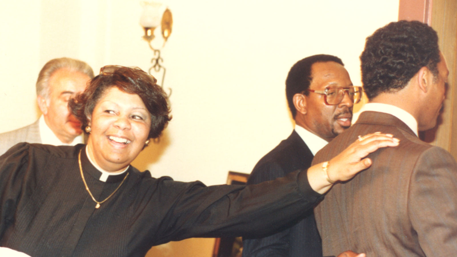 Rev. Gina Thornton reaches toward Rev. Jesse L. Jackson in a gesture of reverence during a gathering.