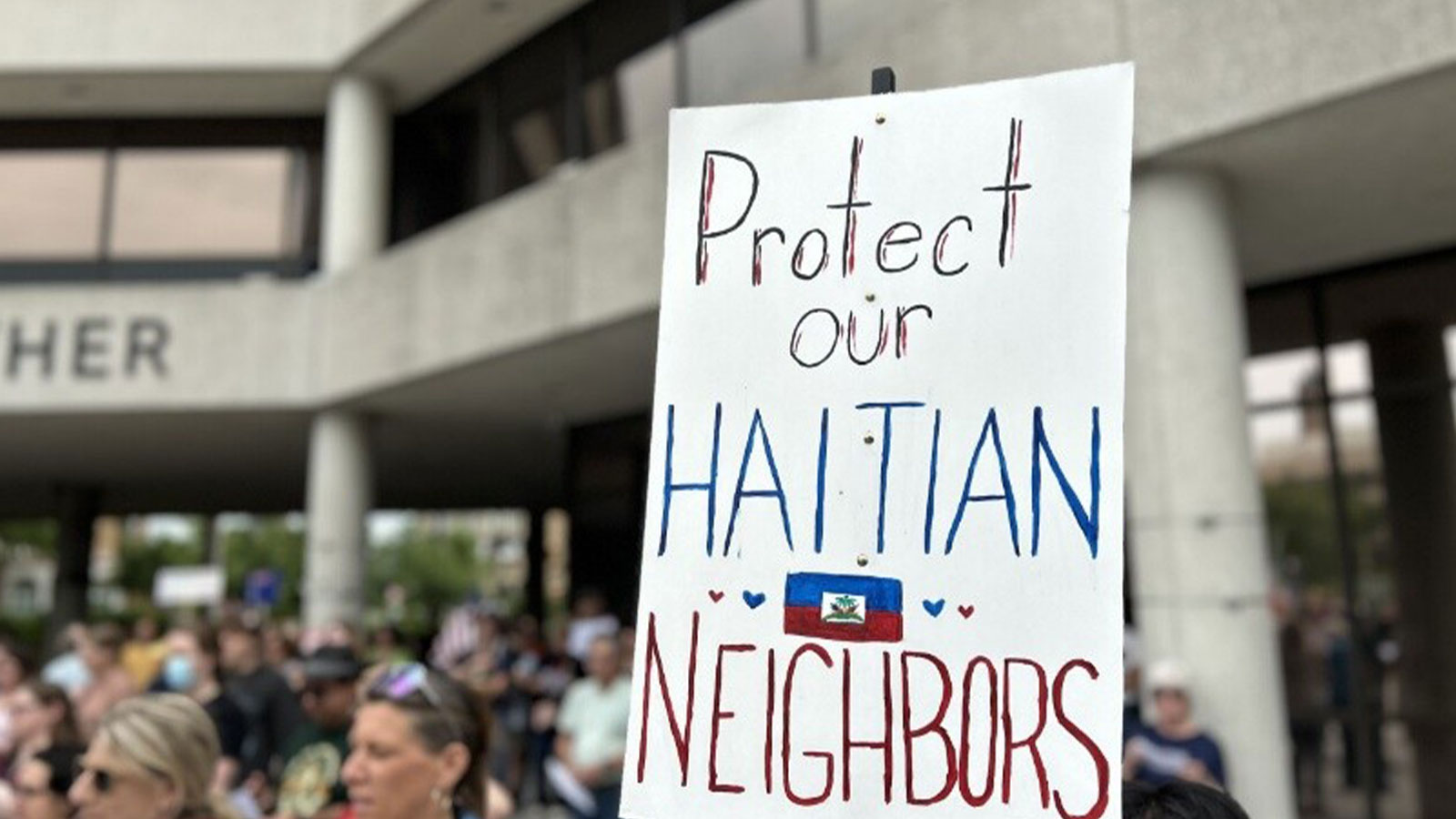 Supporters gather at a community rally in support of Haitian neighbors.