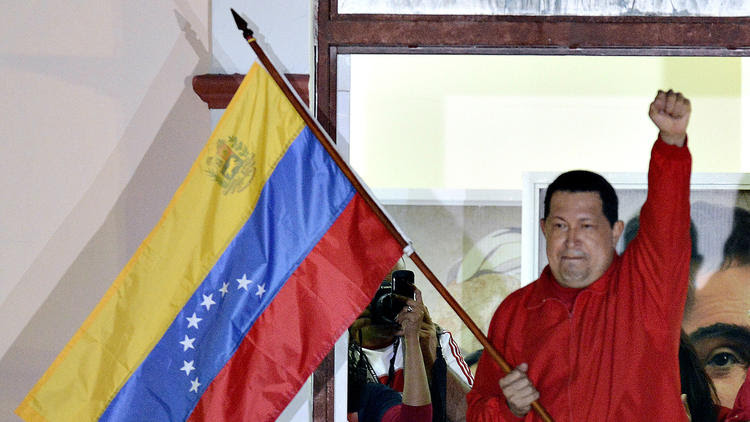 Then-Venezuelan President Hugo Chavez raises his fist while speaking to sup