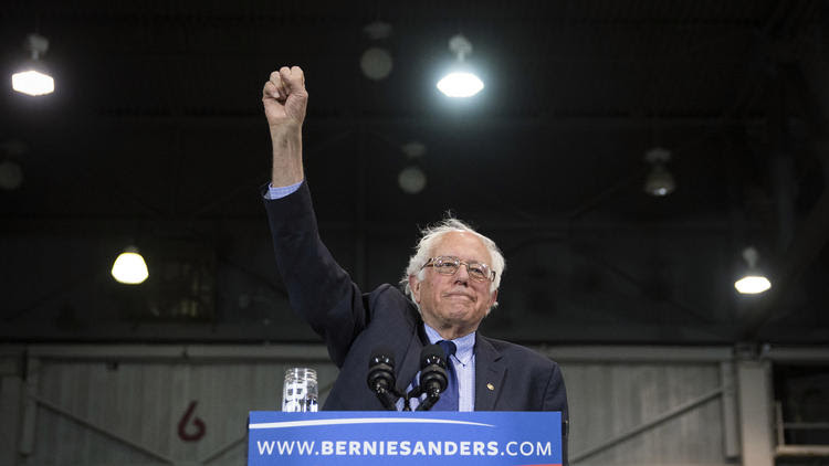 Sen. Bernie Sanders raises his fist to acknowledge the crowd before he spea