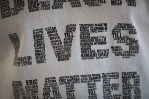 A man wears a shirt bearing names of black people shot by police in the form of the words “Black Lives Matter” at the site where an unarmed black man, Alfred Olango, was shot and killed by police in El Cajon, Calif., earlier in the week of Sept. 29, 2016.