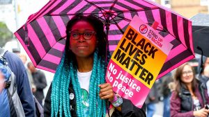 Protester with Black Lives Matter placard at a vigil for Rashan Charles, London, UK, July 29, 2017