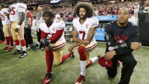 In this Dec. 18, 2016, file photo, San Francisco 49ers quarterback Colin Kaepernick (7) and outside linebacker Eli Harold (58) kneel during the playing of the national anthem before an NFL football game against the Atlanta Falcons in Atlanta. (AP Photo/John Bazemore, File)