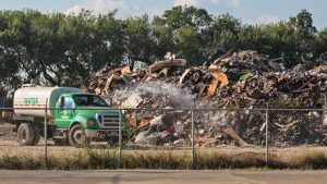 Truck spraying water to mitigate dust particles in the air at a temporary dumpsite on 19th Street in Port Arthur, Texas.