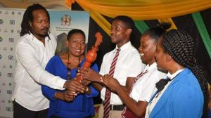 Minister of Culture, Gender, Entertainment, and Sport, Olivia Grange (2nd left), assists in displaying the CARICOM Reparations Youth Relays Baton at the launch of the Jamaican leg of the project yesterday at the Morant Villas in St Thomas. Others (from left) are member of the National Council on Reparations (NCR), Steven Golding; Head Boy at Paul Bogle High School, Daniel Reid; Head Girl at the school, Renae Robinson; and teacher at the institution, Lorraine Williams.