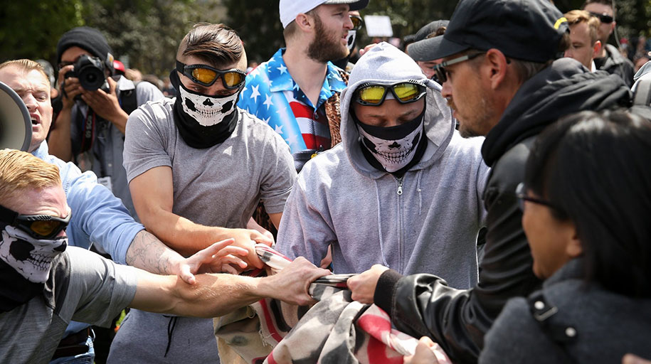 RAM members (left to right) Daley, Robert Boman, and Spencer Currie and Identity Evropa founder Nathan Damigo in a blue collared shirt wrestle a banner away from anti-fascist protesters on April 15, 2017, in Berkeley, California.