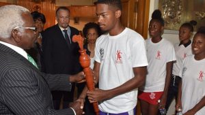 Speaker of the House of Representatives, Hon. Pearnel Charles (left), accepts the relay torch from Karim Murray (fourth right) a participant in the Reparations Youth Baton Relay and Rally. Others observing (from second left) are Deputy Clerk of the Houses of Parliament, Valrie Curtis; President of the Senate, Tom Tavares-Finson; Clerk to the Houses of Parliament, Heather Cooke; and other participants in the relay. The Reparations Youth Baton Relay and Rally is a CARICOM project aimed at building awareness among young people across the region about the issues surrounding the reparations movement and agenda.