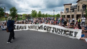 Protesters display a sign during a march against the not-guilty verdict of Jeronimo Yanez, the police officer who shot school teacher Philando Castile, on June 18, 2017, in St. Anthony Village, Minnesota.