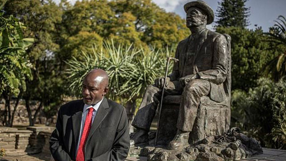 Namibian former Culture Minister Kazenambo Kazenambo stands by a statue of Chief Hosea Katjiku-Ru-Rume-Kutako as he speaks of talks and negotiations about the alleged genocide committed by German forces against Herero and Nama people in 1904.