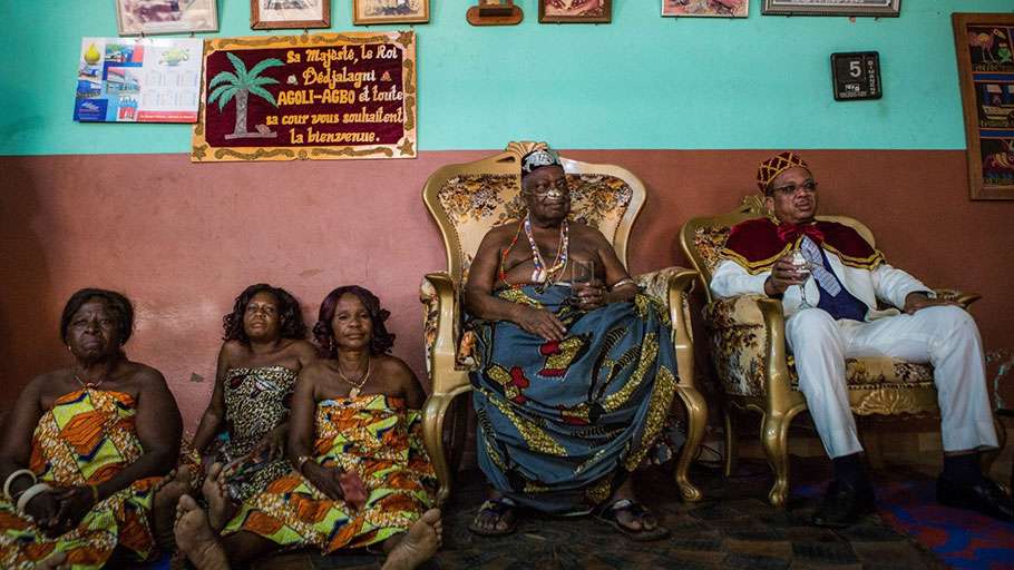The king of Abomey, Dédjalagni Agoli-Agbo, sits between women from his family and the new “Chacha,” leader of the de Souza family, Moise de Souza, in Abomey, Benin in January.