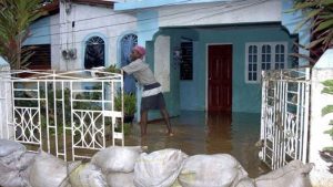 A man drains water from his house flooded after the passage of Hurricane Dennis in the city of Kigston, Jamaica