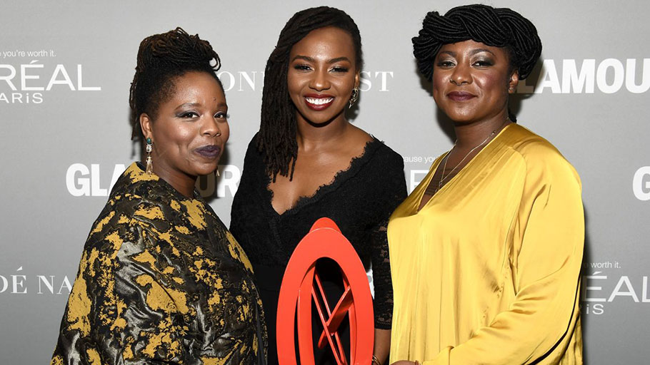 Honorees Patrisse Khan-Cullors, Opal Tometi, and Alicia Garza pose with an award during Glamour Women of the Year 2016 at NeueHouse Hollywood in 2016.