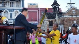 Claudia Gardner Mayor of Montego Bay and Chairman of the St. James Municipal Corporation, Councillor Homer Davis (left), accepts the Flames of Freedom Emancipation Torch from Javon Mendis of Maroon Town, during the Western Jamaica Leg of the CARICOM Reparations Youth Baton Relay and Rally, which took place in Sam Sharpe Square on December 27.