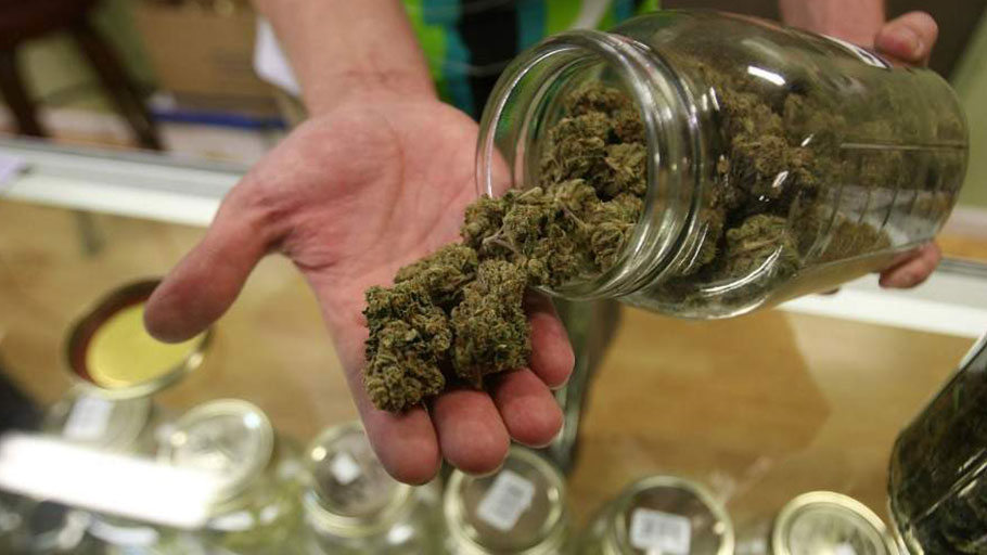 Dave Warden, a bud tender at Private Organic Therapy (P.O.T.), a non-profit co-operative medical marijuana dispensary, displays various types of marijuana available to patients on October 19, 2009 in Los Angeles, California.