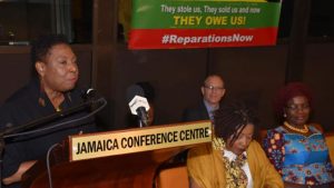 Photo: Mark Bell Minister of Culture, Gender, Entertainment and Sport, Hon. Olivia Grange (at podium), speaks at Reparation Youth Conference, held at the Jamaica Conference Centre in downtown, Kingston, on Friday (May 25). Seated (from left) are: Co-Chair, National Council on Reparations in Jamaica, Professor Verene Shepherd and Nigerian High Commissioner to Jamaica, Her Excellency Janet Olisa. In the background is Charge D’Affaires at the South African High Commission, Mr. Phillip Riley.