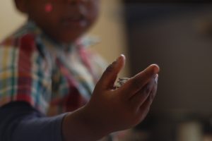 Black child holding coins - Serede Jami / Eyeem / Getty Images