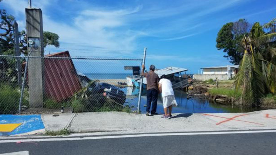 Puerto Ricans survey hurricane damage.