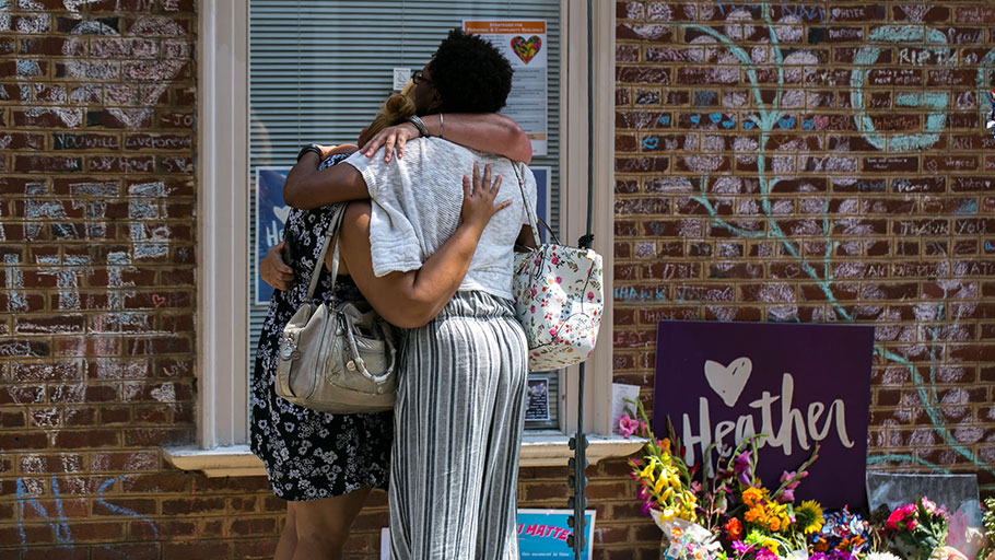 Mourners embrace in front of chalk messages that line the walls outside the buildings where Heather Heyer was killed by a speeding vehicle as she was protesting the Unite The Right rally in Charlottesville, Virginia. Photograph: Logan Cyrus/AFP/Getty Images