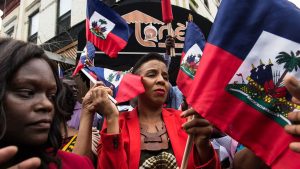 Laurie Cumbo, center, the City Council majority leader, and Assemblywoman Rodneyse Bichotte, left, passed out Haitian flags.