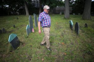 Ben Jacques walks among the unmarked graves of slaves at the Old Burying Ground in Stoneham.