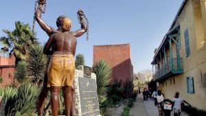 Senegalese women walk past a monument to slavery near the Slave house on Goree island 3km off Dakar, Senegal