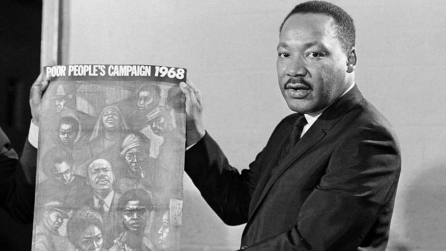 Dr. Martin Luther King displays the poster to be used during his Poor People's Campaign, March 4, 1968, one month before he was shot to death by a sniper.