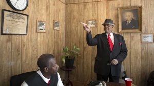 Melvin J. Fulton (right) points to Dexter Vaughn's (left) father's certificate of embalming at the Cox Brother's Funeral Home. Vaughn's father, Dexter I. Vaugh, was one of the oldest embalmers in the city when he died. Image by Evey Wilson