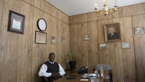 Dexter Vaughn, 62, sits at his desk in the funeral home. Vaughn grew up coming to this neighborhood because his father worked at this funeral home. Image by Evey Wilson