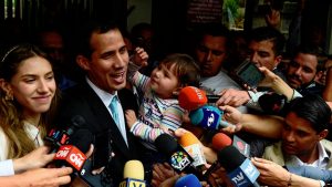 Opposition leader and self-proclaimed 'acting president' Juan Guaido (2-L) talks to the press as he holds his daughter Miranda (3-L), next to his wife Fabiana Rosales (L), outside his home in Santa Fe, Caracas on January 31, 2019. - Venezuela's self-proclaimed acting president Juan Guaido on Thursday accused socialist leader Nicolas Maduro's security forces of trying to intimidate his family. Guaido, the opposition leader challenging Maduro's rule, said the security service FAES had gone to his house asking for his wife, Fabiana.