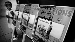 A young girl attends a slavery reparations protest outside of the New York Life Insurance Company offices on August 9, 2002, in New York City.