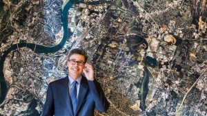 Chattanooga, Tennessee, Mayor Andy Berke stands in front of an aerial image of the city in November 2014. Berke has been a major promoter of the city’s high-speed municipal fiber optic network.