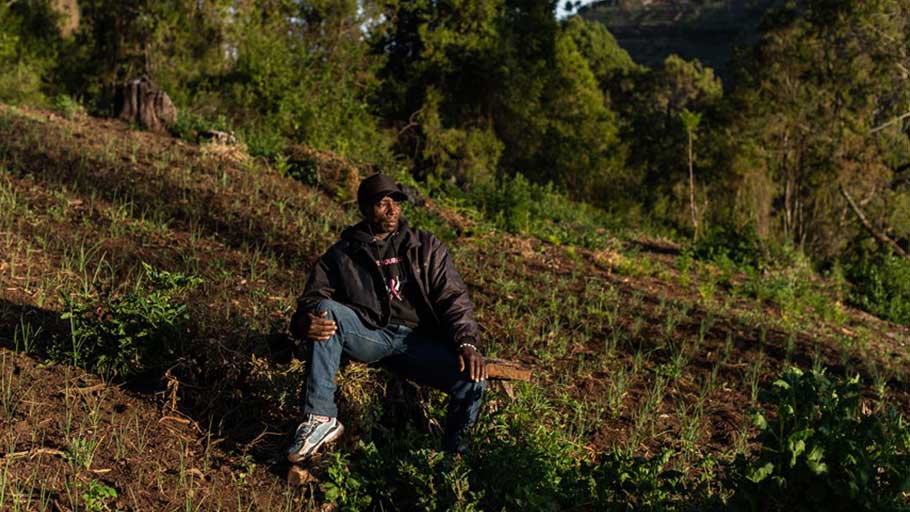 Garlic farmer Peter Munene Ndururi rests in his field in Embaringo, Kenya