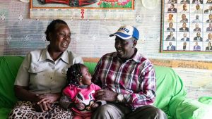 Charles Gichuhi Ngari sits with his wife, Esther Wairimu Gichuhi, and granddaughter Rose Wamboi Njoroge at their home in Embaringo, Kenya