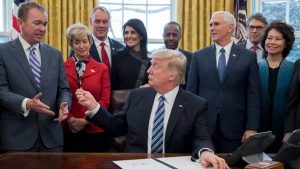 President Donald Trump hands his pen to Office of Management and Budget Director Mick Mulvaney, after signing an executive order reorganizing the executive branch.