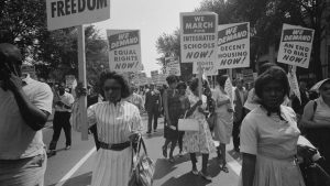 Civil rights advocates carry placards during the March on Washington for Jobs and Freedom on August 28, 1963, in Washington