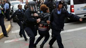 A demonstrator protesting the murder of Michael Brown is arrested by cops in riot gear on November 30, 2014, in St. Louis, Missouri.