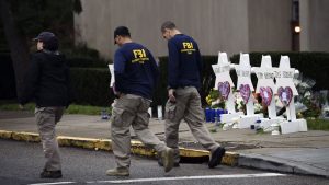 FBI agents walk past a memorial outside the Tree of Life synagogue in Pittsburgh