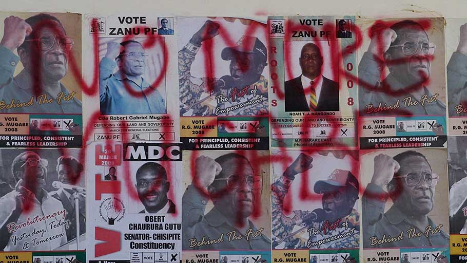 Mugabe election posters are covered in opposition MDC slogans, in Harare, 2008.