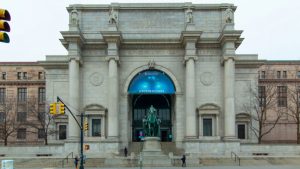 The statue depicts Roosevelt on horseback, with a Native American man and an African man on foot on each side.