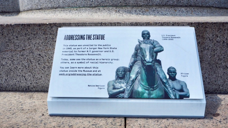 The plaque currently on view adjacent to the monument at the center of the Addressing the Statue exhibition