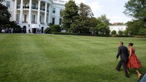 Former President Barack Obama and First Lady Michelle Obama walk across the South Lawn.