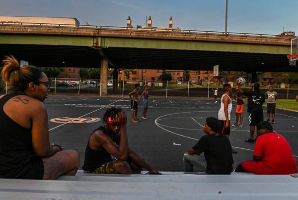 Kids play basketball at Wilson Park near where Interstate 81 slices through a public housing complex in Syracuse, N.Y.
