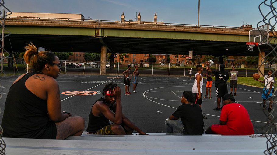 Kids play basketball at Wilson Park near where Interstate 81 slices through a public housing complex in Syracuse, N.Y.