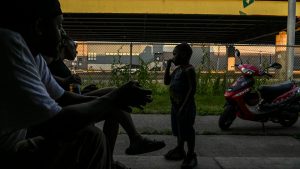 Capone, Celeste Wallace and 3-year-old Ezekiel Wallace sit on their porch at Pioneer Homes.