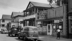 A woman walks past Schor's Market on Harrison Street in Syracuse's 15th Ward in 1965.