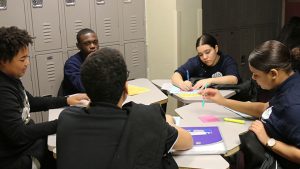 Justin Ventura, far left, discusses the 1619 readings with his classmates.