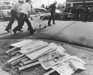 WVO signs lay on the ground as a wounded person is taken away by medics.