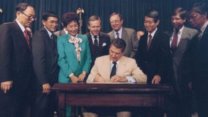 President Reagan signs the Civil Liberties Act of 1988, which granted reparations to Japanese Americans