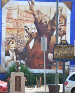 A Pennsylvania historic marker, bust and mural in West Philadelphia commemorating a rally where Martin Luther King Jr. spoke