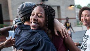 Cheyenne Brewington receives a hug by volunteers of the Free Black Mamas DMV movement